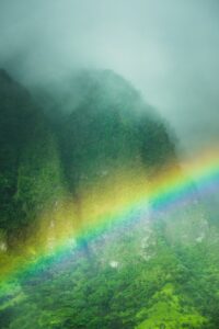 Photo by Harrison Steen A rainbow arcs over the lush, green mountains.